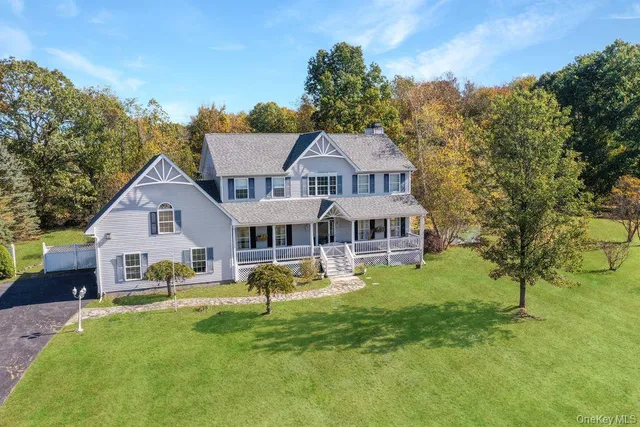 a front view of a house with a garden and trees