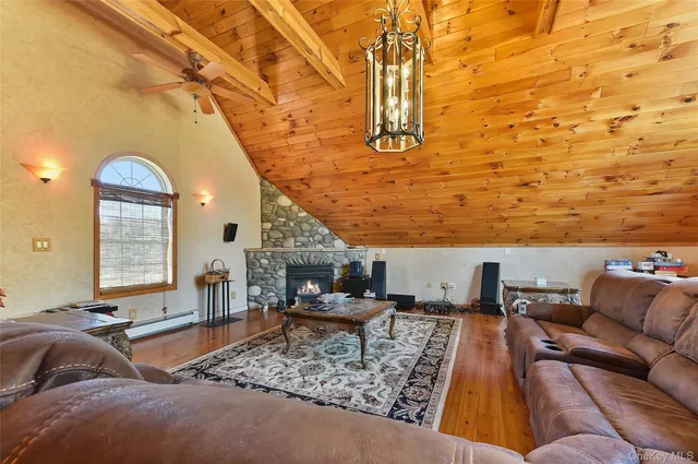 a living room with furniture a large window and wooden floor