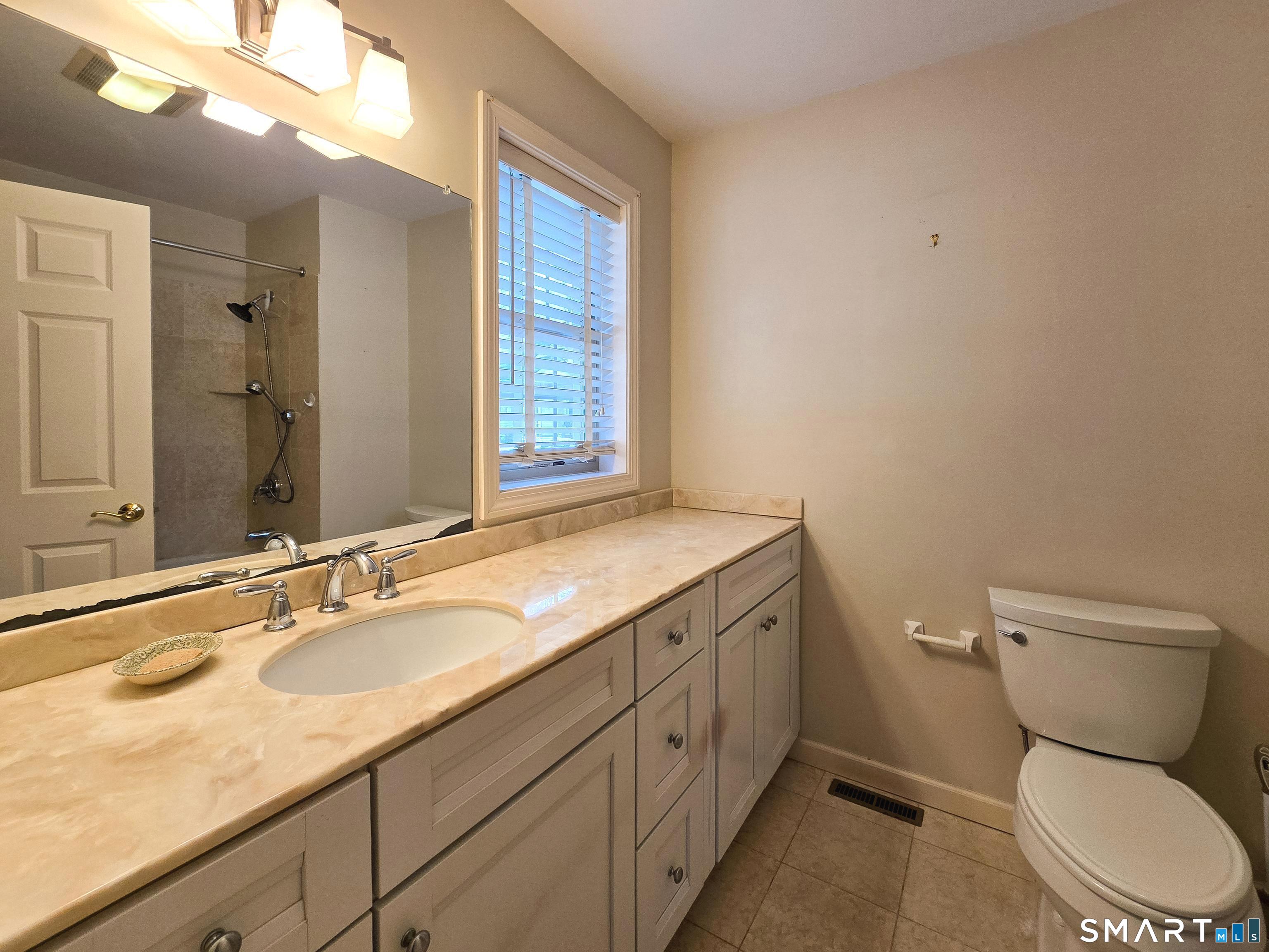 1 Bittersweet Lane, Unit 1 East Lyme, CT 06357 - Photo 20 of 35 a bathroom with a granite countertop toilet sink and mirror
