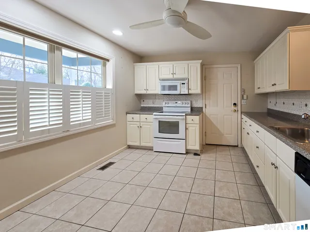 a view of a room with wooden floor chandelier and windows