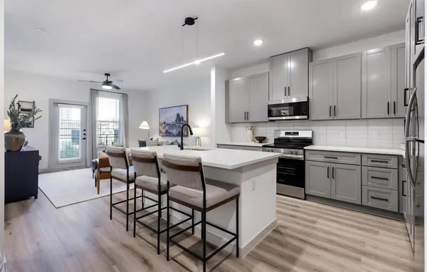 a kitchen with kitchen island granite countertop wooden floors and white appliances
