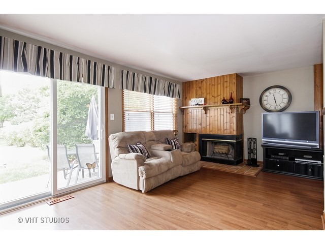 719 South Raven Road Shorewood, IL 60404 - Photo 5 of 11 a living room with furniture a fireplace and a large window