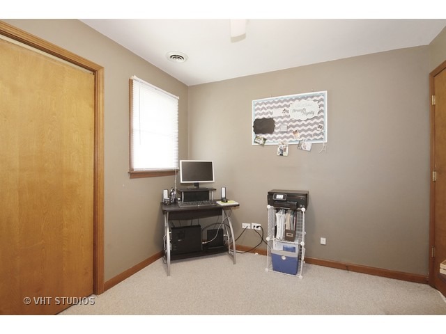 719 South Raven Road Shorewood, IL 60404 - Photo 9 of 11 a workspace room with hardwood wall and painting on the wall