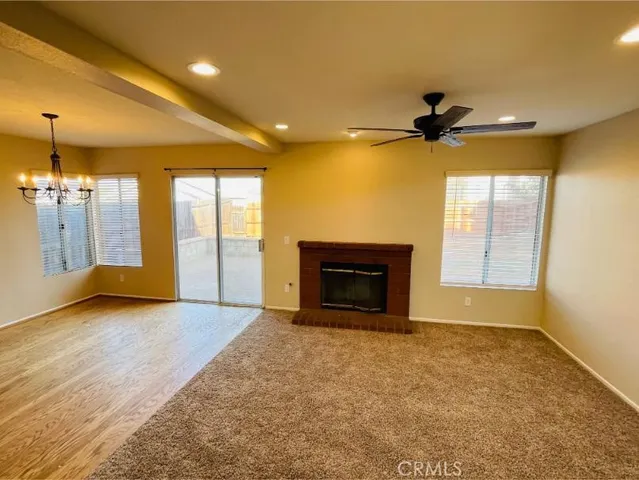 a view of an empty room with a fireplace and a window