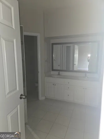 a bathroom with a sink vanity and mirror