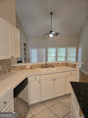 a view of an empty room with wooden floor fireplace and a window