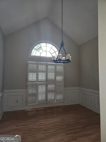 an empty space with wooden floor and windows