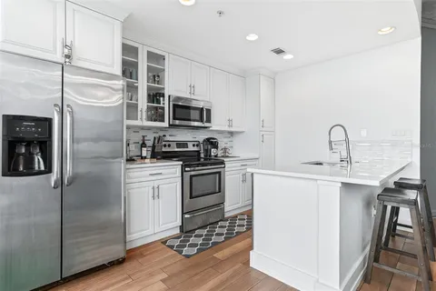 a kitchen with stainless steel appliances granite countertop a sink a stove a microwave and cabinets