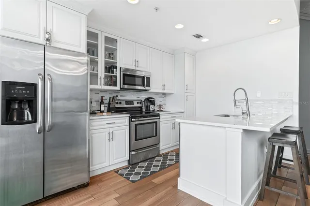 a kitchen with stainless steel appliances granite countertop a sink a stove a microwave and cabinets