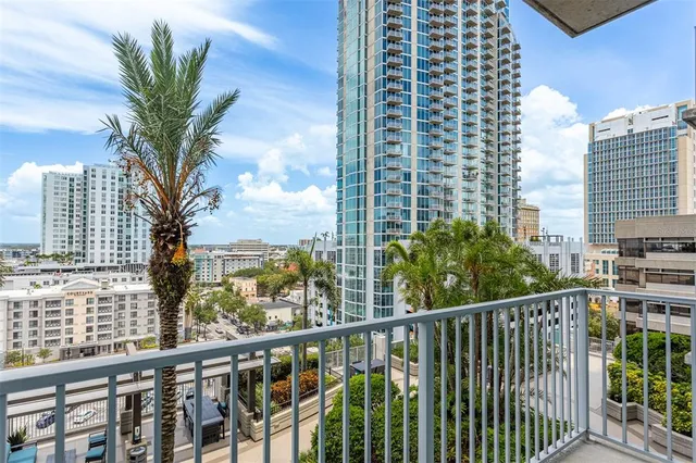 a view of a balcony with a floor to ceiling window and palm tree