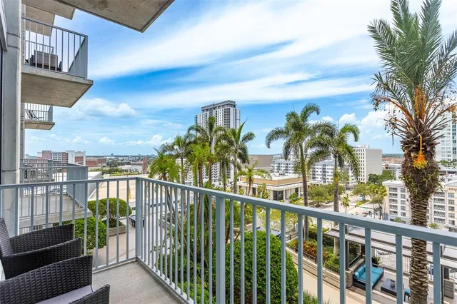a front view of a building with a garden and trees