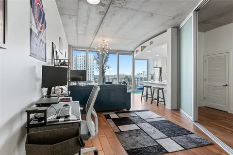 a living room with couches a fireplace and a dining table with wooden floor