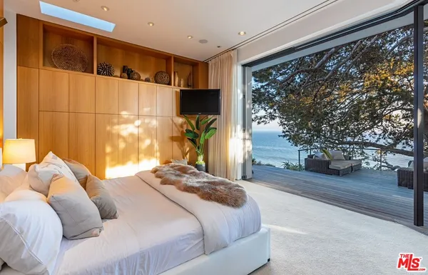 a living room with furniture floor to ceiling window and wooden floor