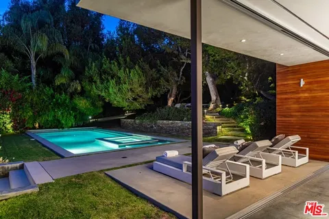 a living room with furniture floor to ceiling window and a flat screen tv