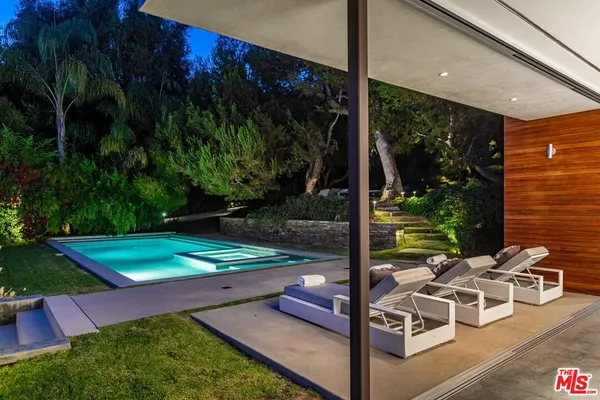 a living room with furniture floor to ceiling window and a flat screen tv