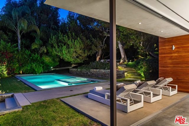 a living room with furniture floor to ceiling window and a flat screen tv