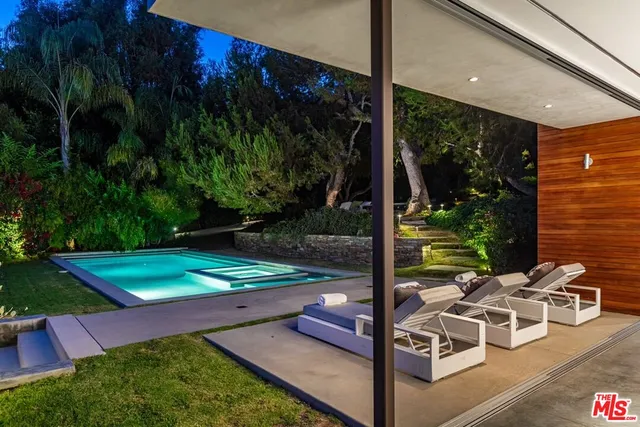 a living room with furniture floor to ceiling window and a flat screen tv