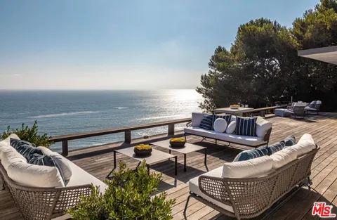 a roof deck with couches and wooden floor