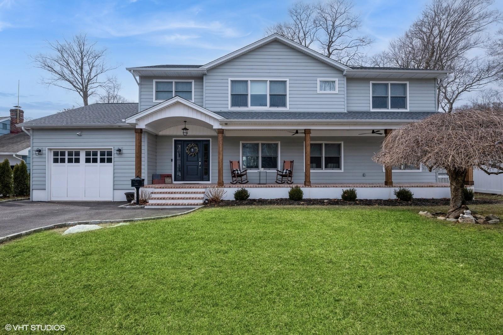 1580 Henry Road Wantagh, NY 11793 - Photo 1 of 1 a front view of a house with a garden and trees