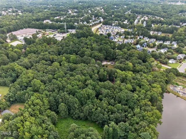 an aerial view of residential houses with outdoor space and trees
