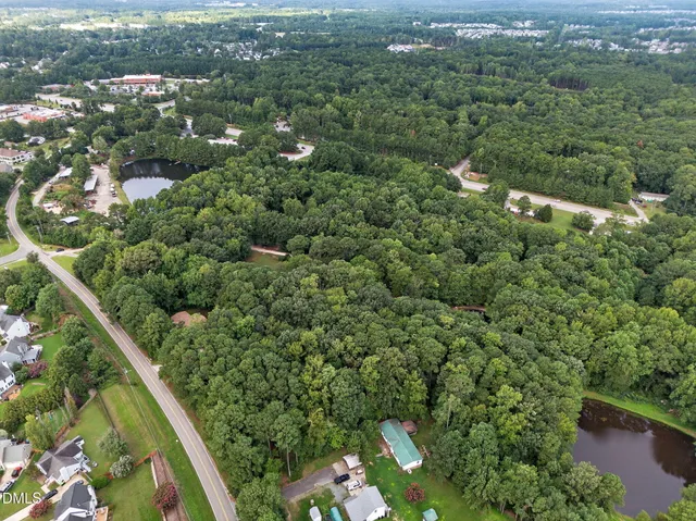 an aerial view of residential houses with outdoor space and trees