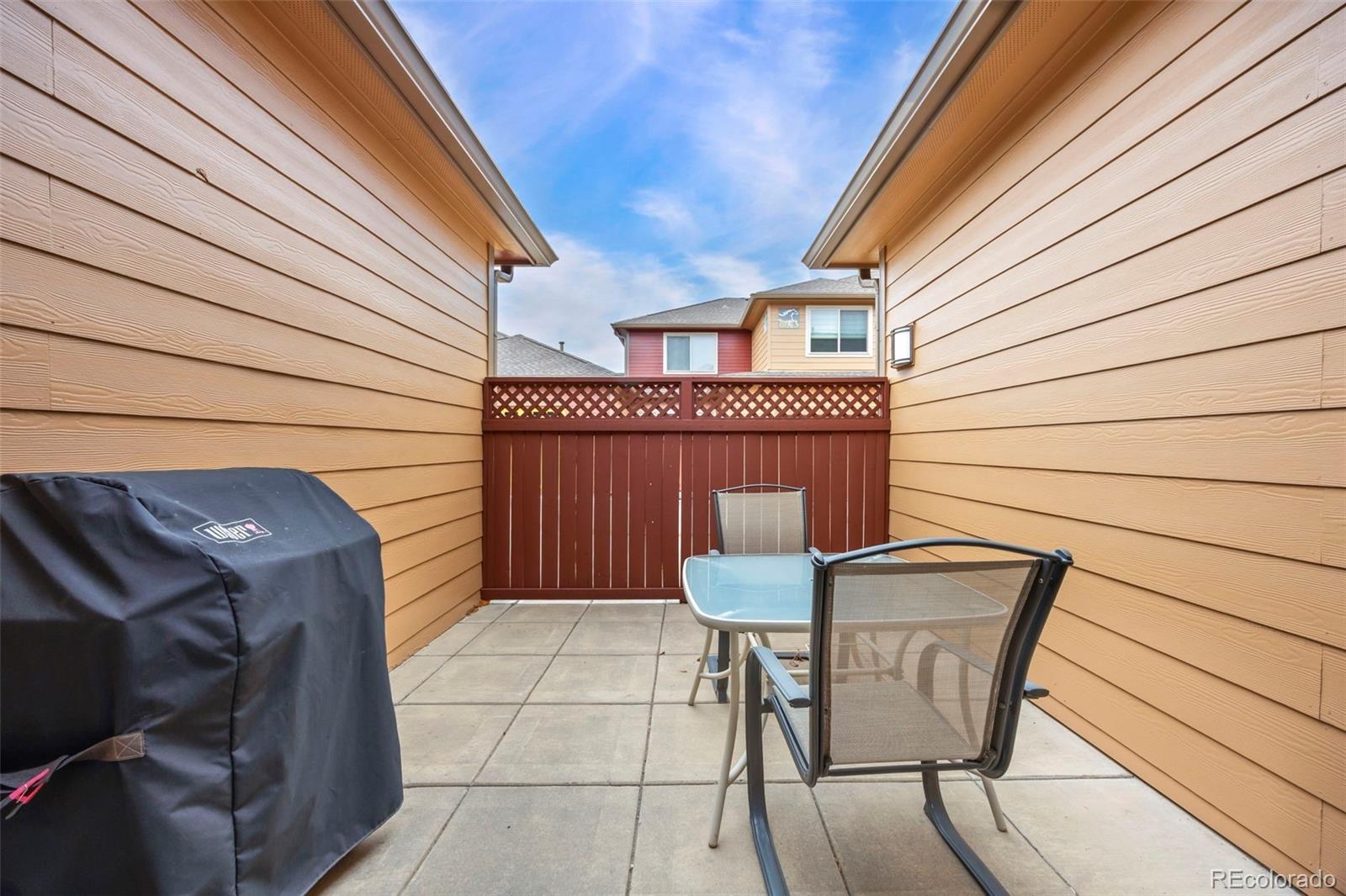 8615 Gold Peak Place, Unit F Highlands Ranch, CO 80130 - Photo 11 of 39 a view of backyard with table and chairs and wooden fence