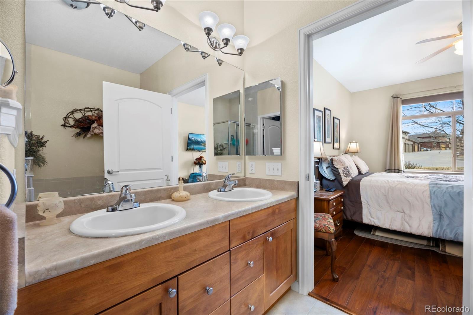8615 Gold Peak Place, Unit F Highlands Ranch, CO 80130 - Photo 15 of 39 a en suite bathroom with a double vanity sink a mirror a lamp and a window