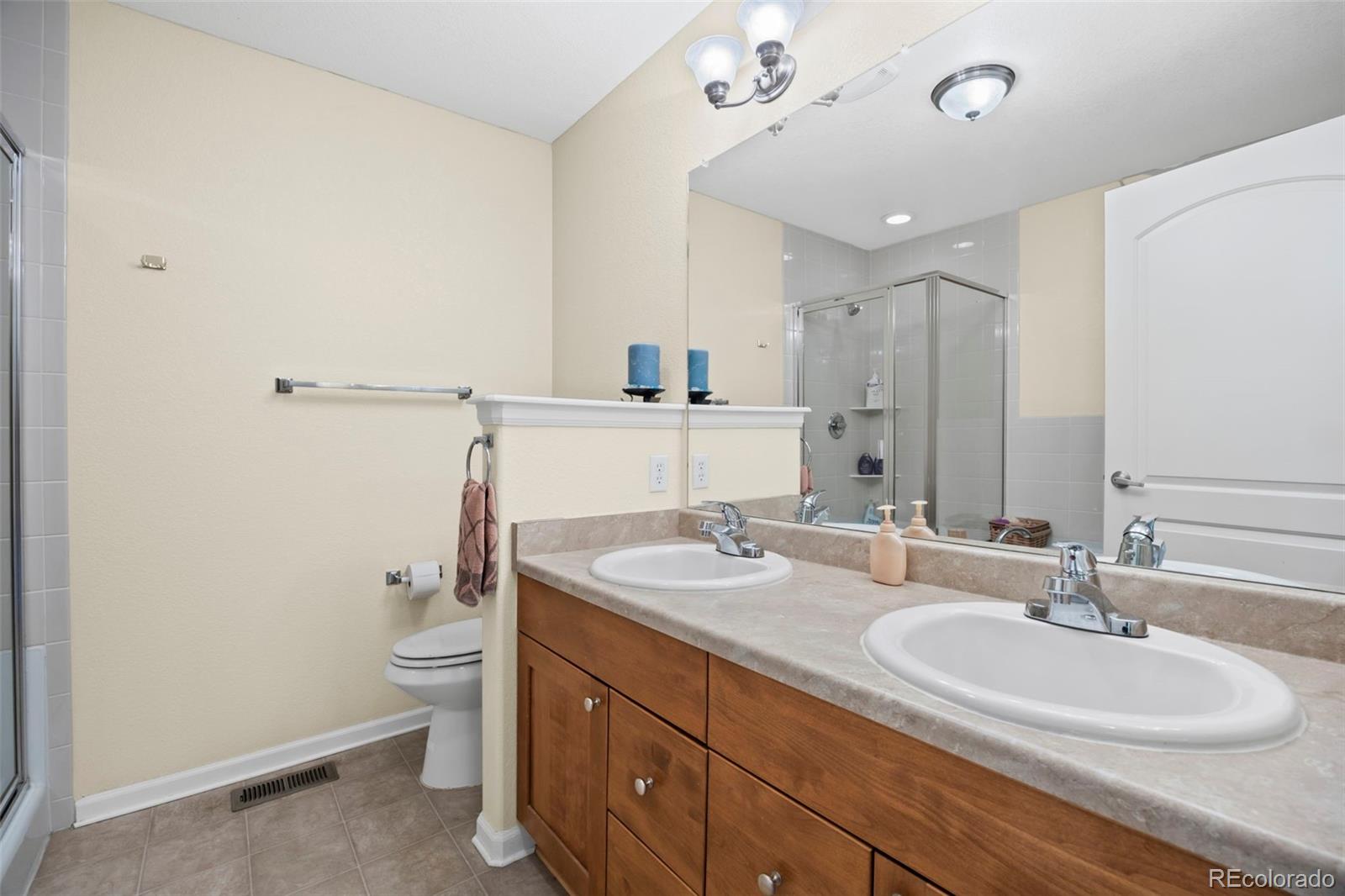 8615 Gold Peak Place, Unit F Highlands Ranch, CO 80130 - Photo 20 of 39 a bathroom with a granite countertop sink a toilet and a mirror