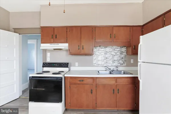 a kitchen with a white stove top oven and refrigerator