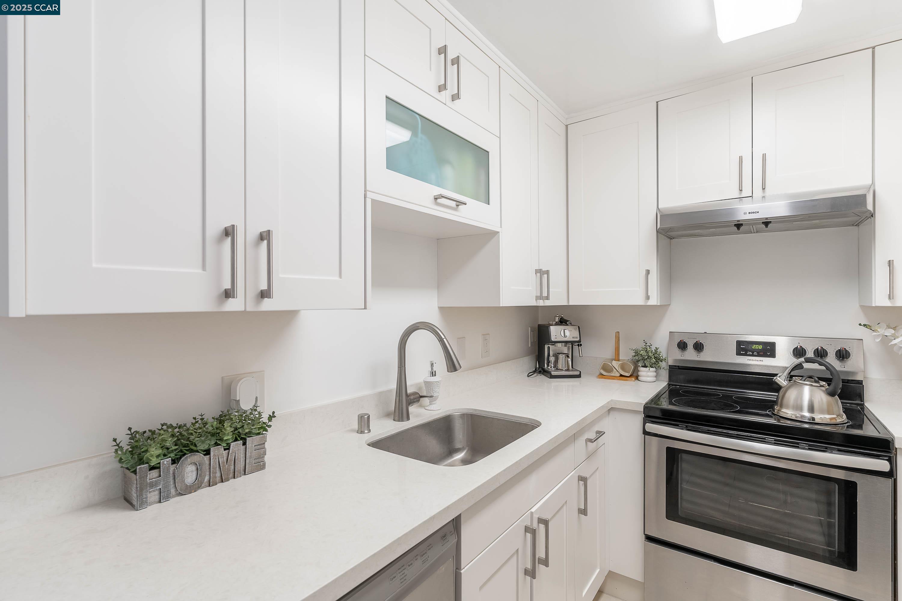5305 Ridgeview Circle, Unit 8 El Sobrante, CA 94803 - Photo 6 of 18 a kitchen with stainless steel appliances white cabinets and a stove top oven