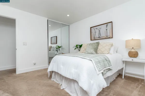 a spacious bedroom with a bed and wall painting
