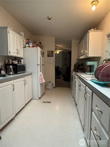 a kitchen with white cabinets and white appliances
