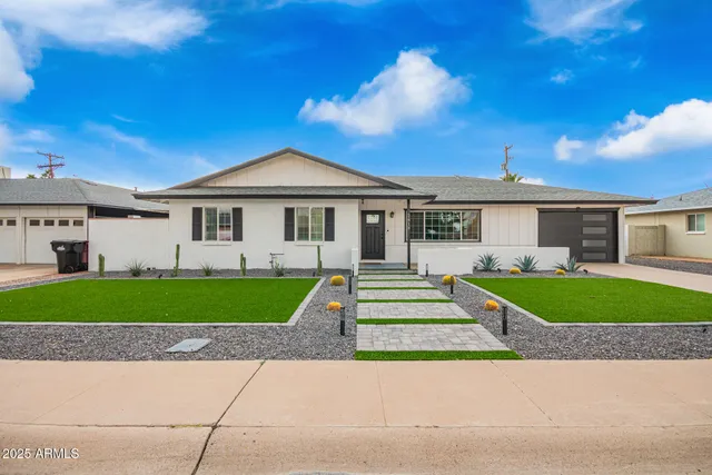 a front view of a house with a garden and plants