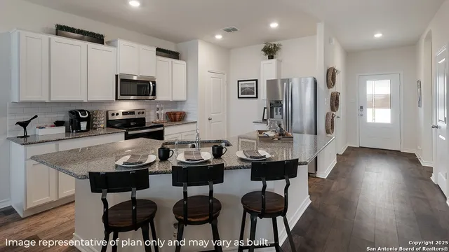 a kitchen with stainless steel appliances kitchen island granite countertop a stove a sink a microwave and a refrigerator