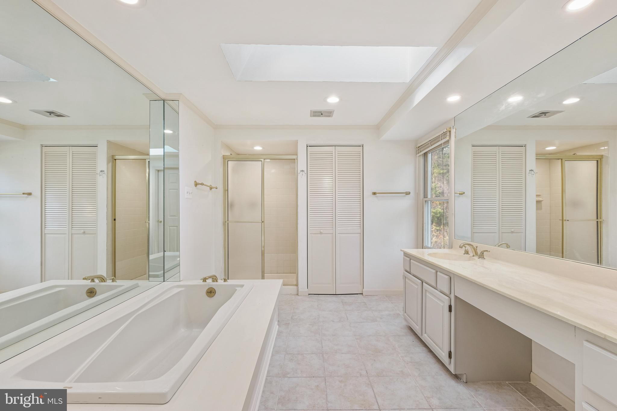 13905 Huxley Cove Court Silver Spring, MD 20906 - Photo 19 of 30 a spacious bathroom with a double vanity sink large mirror and a bathtub