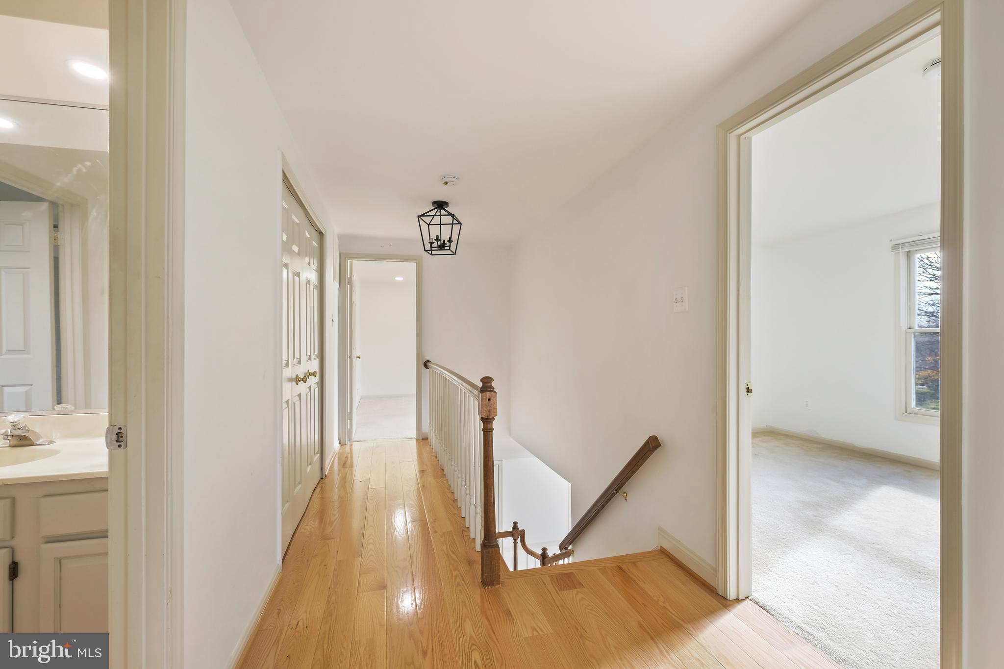 13905 Huxley Cove Court Silver Spring, MD 20906 - Photo 23 of 30 a view of a hallway with wooden floor and a bathroom