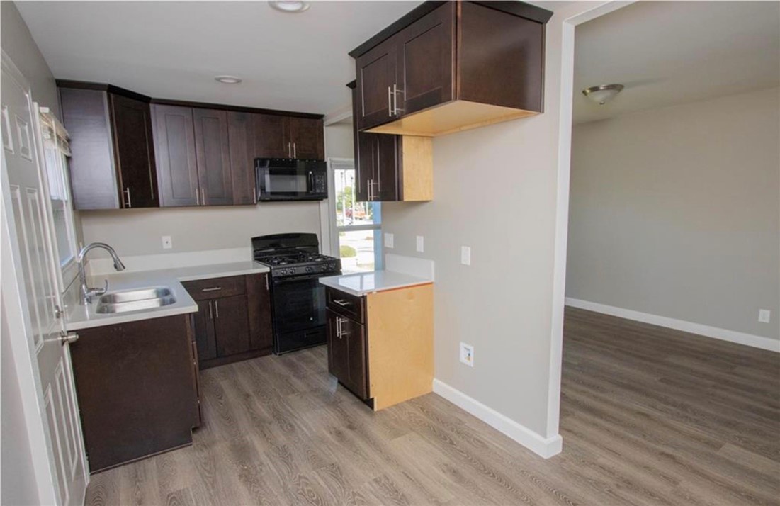 3110 Lime Street Riverside, CA 92501 - Photo 4 of 9 a kitchen with a sink a stove top oven a refrigerator and wooden floor