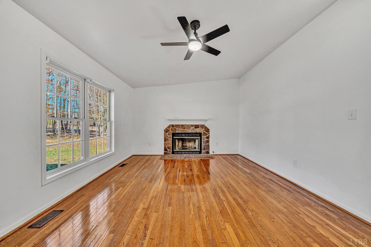 3949 Diamond Hill Road Moneta, VA 24121 - Photo 4 of 30 a view of a livingroom with wooden floor and a ceiling fan