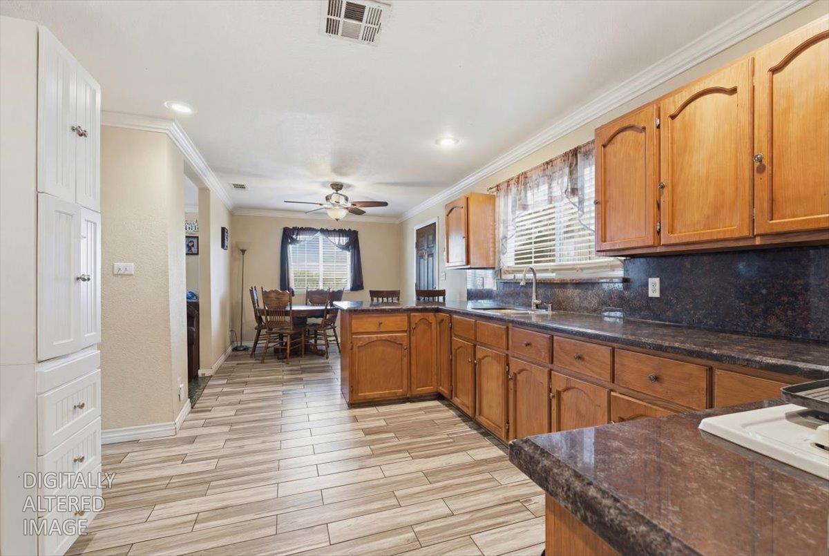 3902 Arch Road Stockton, CA 95215 - Photo 3 of 30 a large kitchen with stainless steel appliances granite countertop a lot of counter space and wooden floors