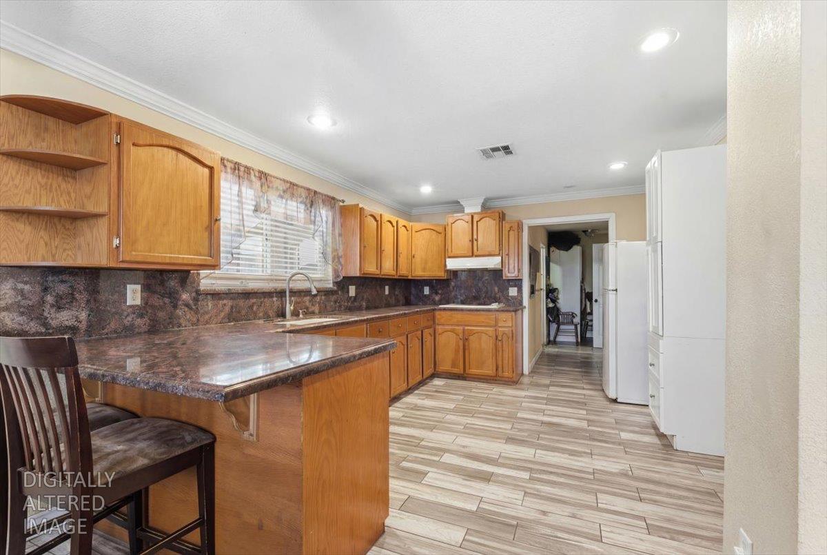 3902 Arch Road Stockton, CA 95215 - Photo 6 of 30 a kitchen with stainless steel appliances granite countertop a refrigerator sink and cabinets