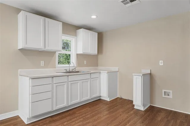 a kitchen with granite countertop white cabinets and white appliances