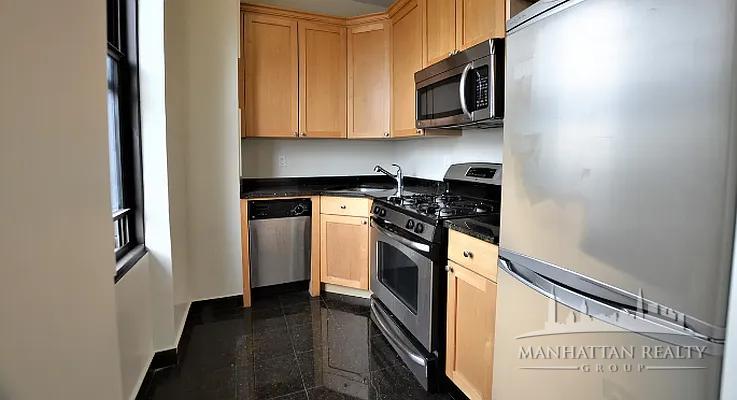 166 2nd Avenue, Unit 3M Manhattan, NY 10003 - Photo 3 of 7 a kitchen with stainless steel appliances granite countertop a stove and a refrigerator