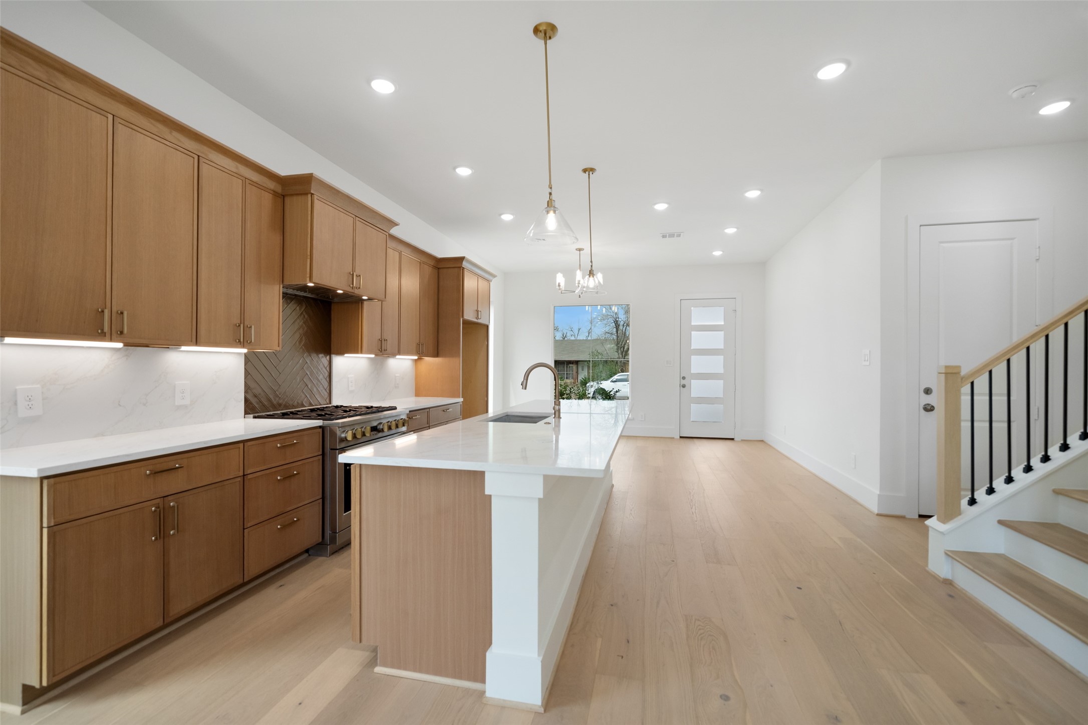 8521 Friendship Road Houston, TX 77080 - Photo 11 of 49 a kitchen with stainless steel appliances kitchen island granite countertop a stove a sink a refrigerator and white cabinets with wooden floor