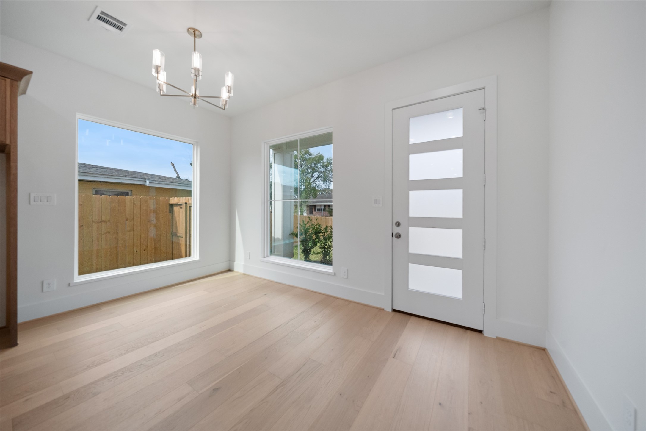 8521 Friendship Road Houston, TX 77080 - Photo 17 of 49 an empty room with wooden floor cabinet and windows