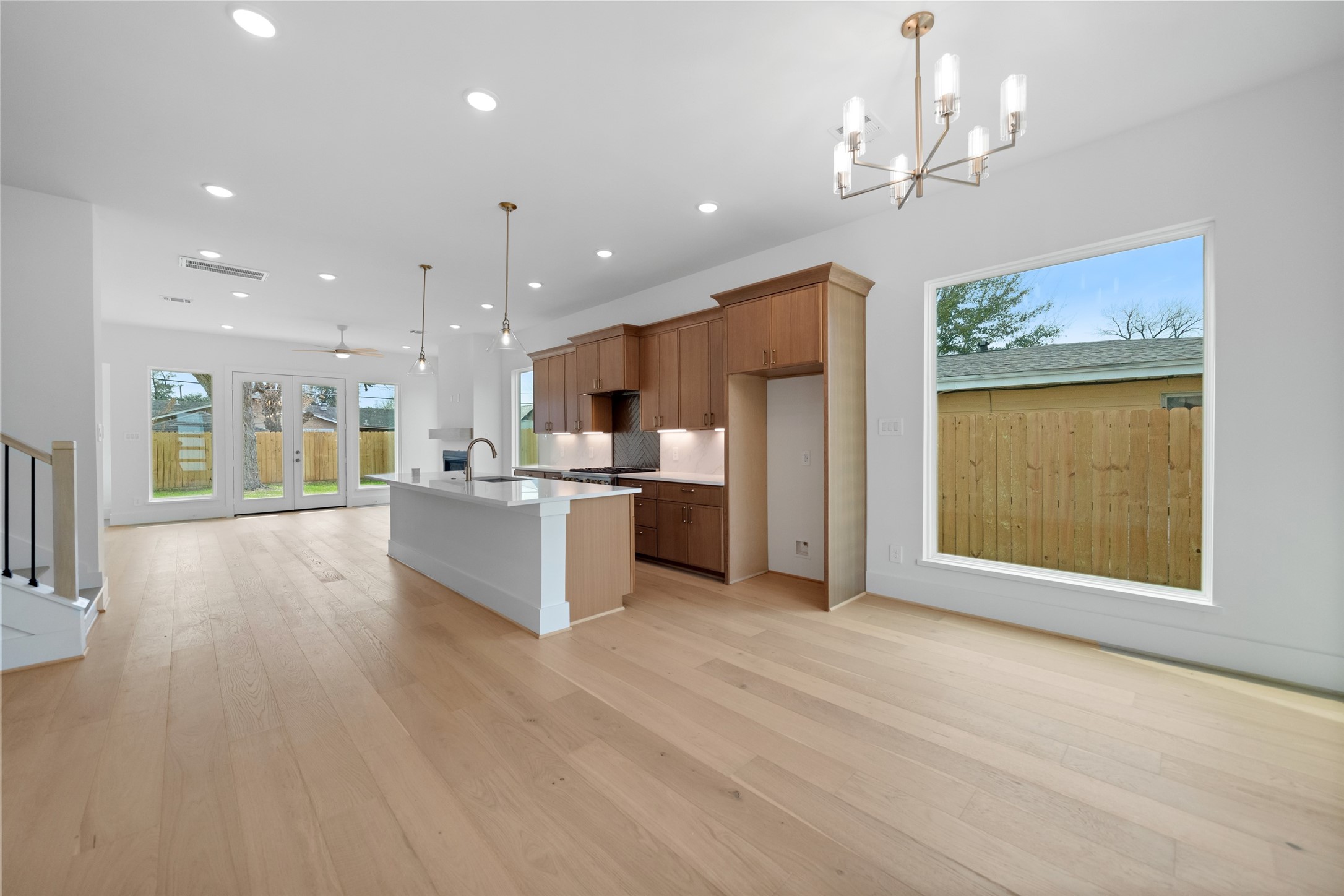 8521 Friendship Road Houston, TX 77080 - Photo 3 of 49 a large kitchen with a lot of kitchen island a sink wooden floor and a refrigerator