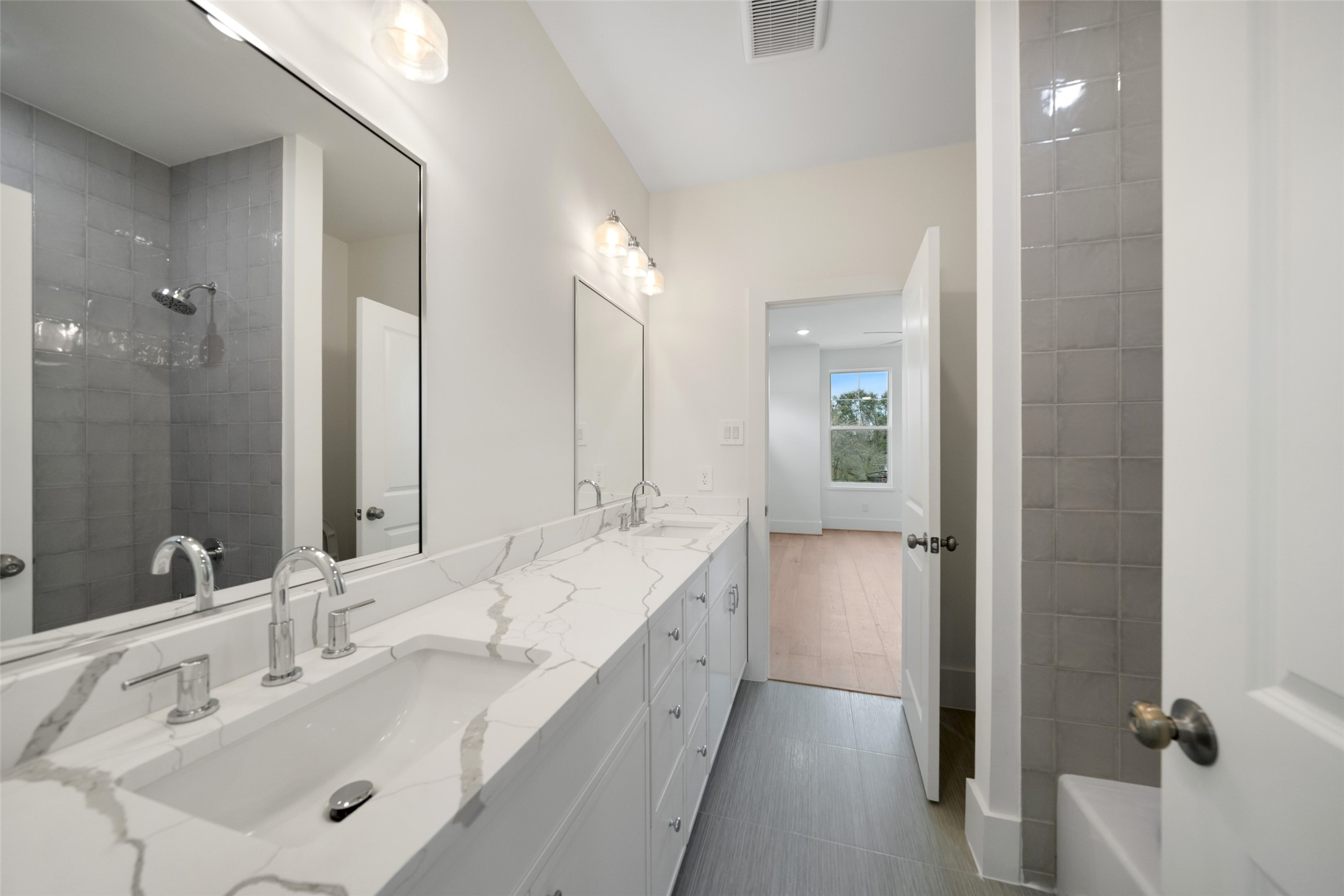 8521 Friendship Road Houston, TX 77080 - Photo 40 of 49 a bathroom with a double vanity sink a mirror and a bathtub