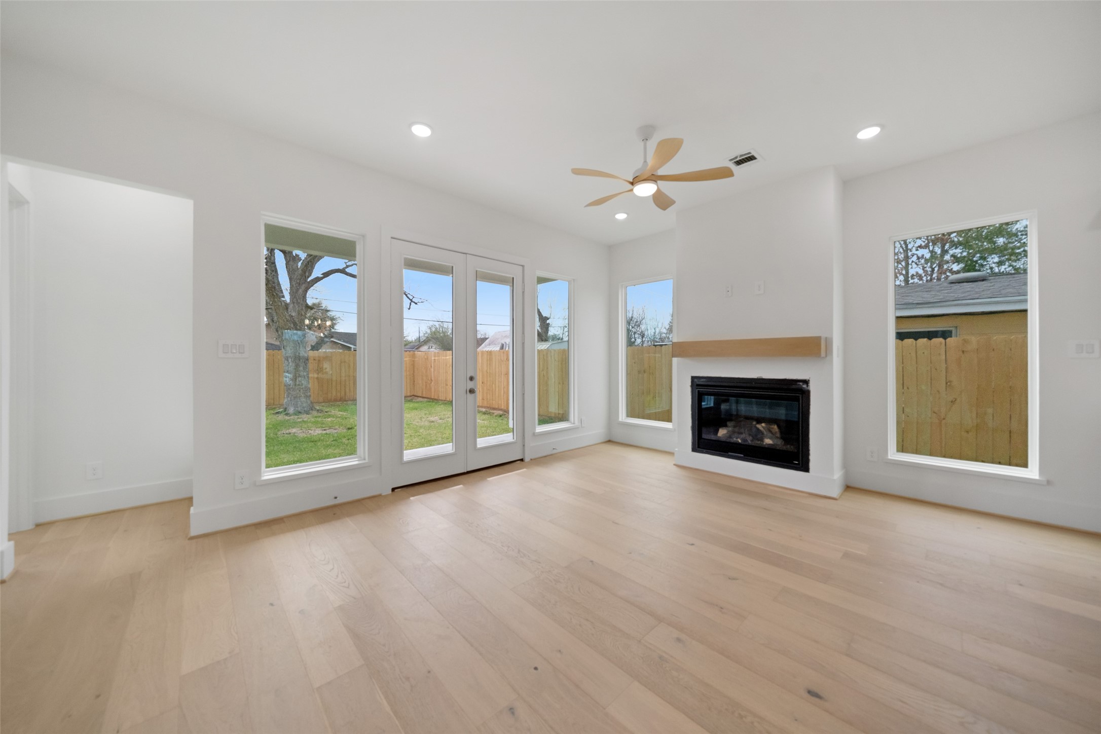 8521 Friendship Road Houston, TX 77080 - Photo 7 of 49 wooden floor fireplace and windows in an empty room