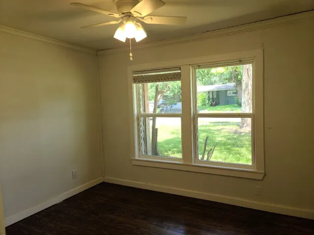 a view of a room with wooden floor and windows