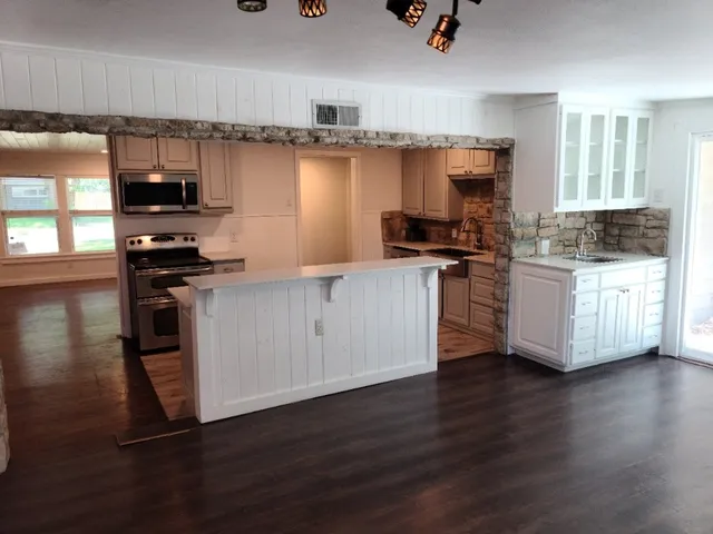 a kitchen with stainless steel appliances granite countertop a stove and a sink