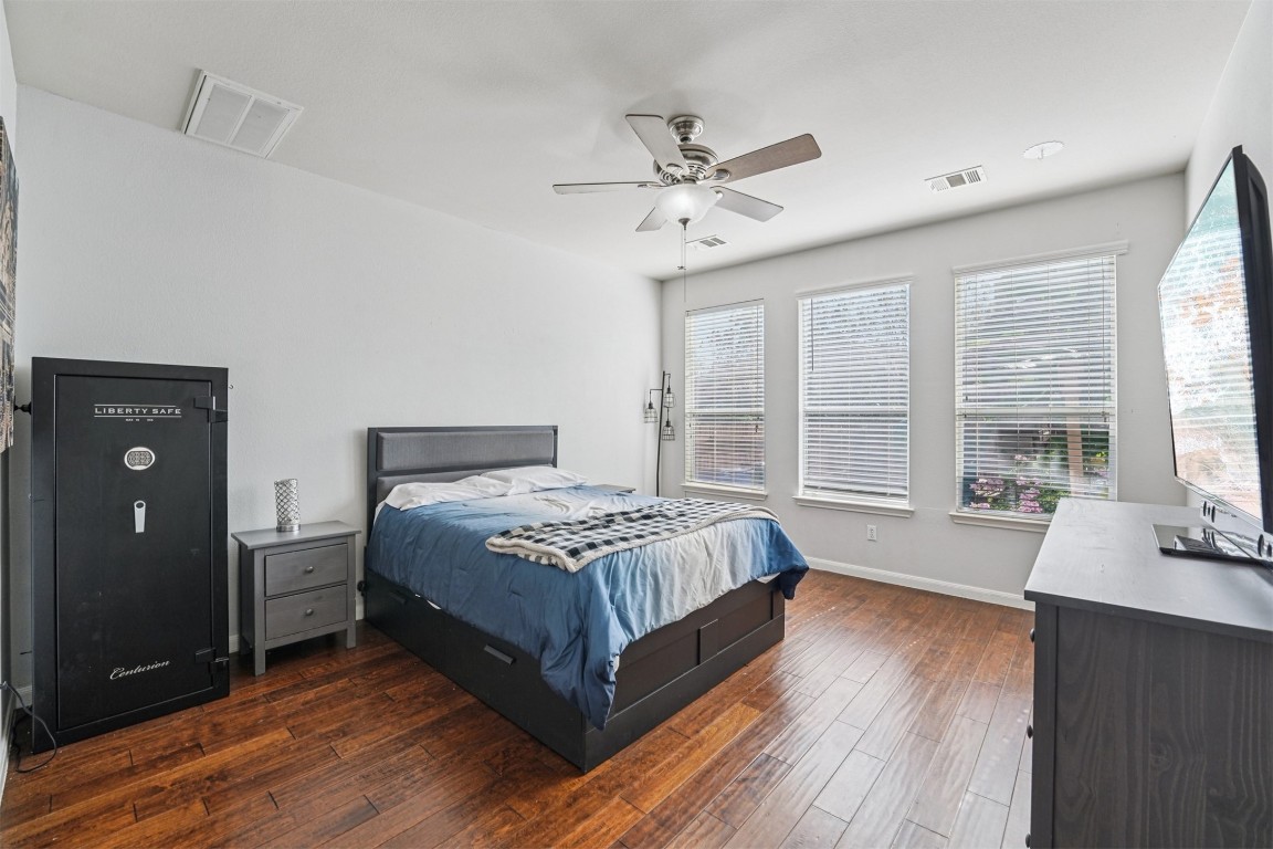 2301 Ambling Trail Pflugerville, TX 78660 - Photo 11 of 34 a spacious bedroom with a large bed a chandelier and windows
